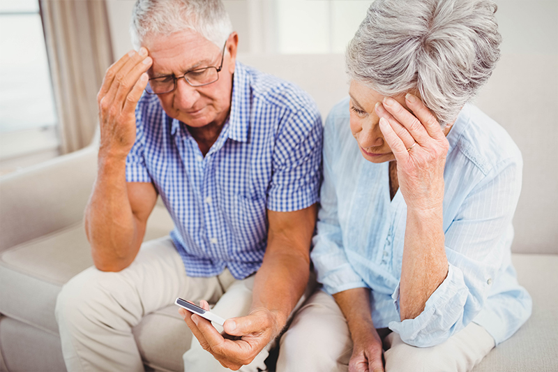 Older couple looks at their phone worried