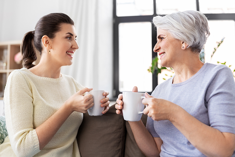 Mom and Daughter enjoyign cup of coffee on a couch