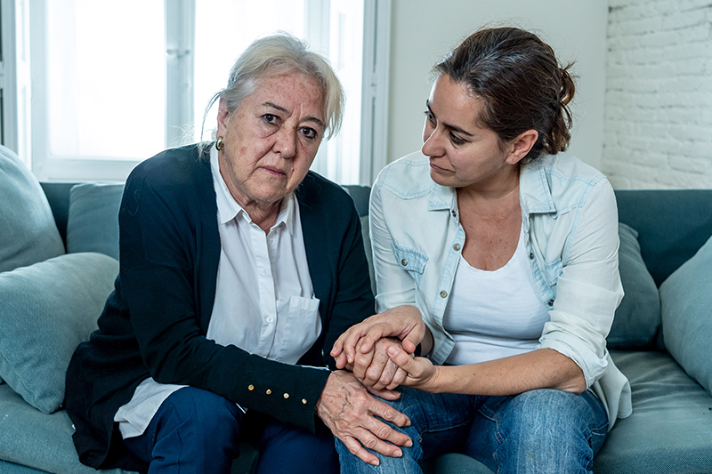 Depressed senior mother and daughter embracing each other grieving loss of loved one