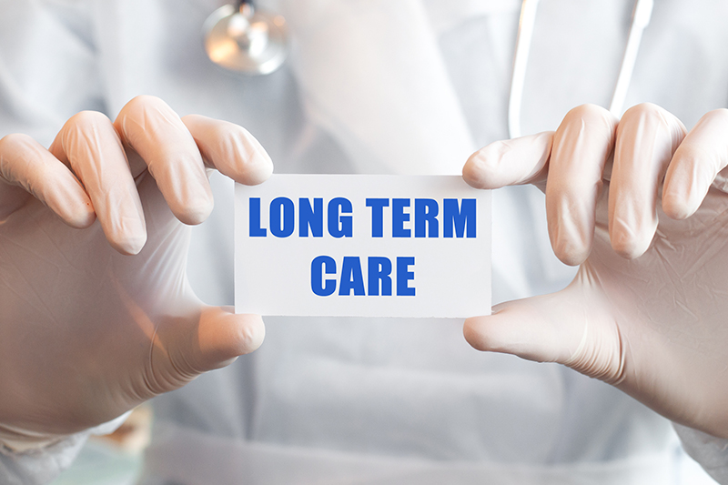 Doctor holding a card with text LONG TERM CARE